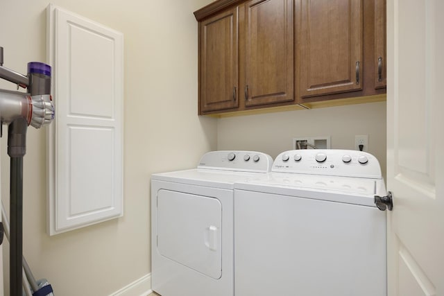 washroom featuring independent washer and dryer and cabinet space