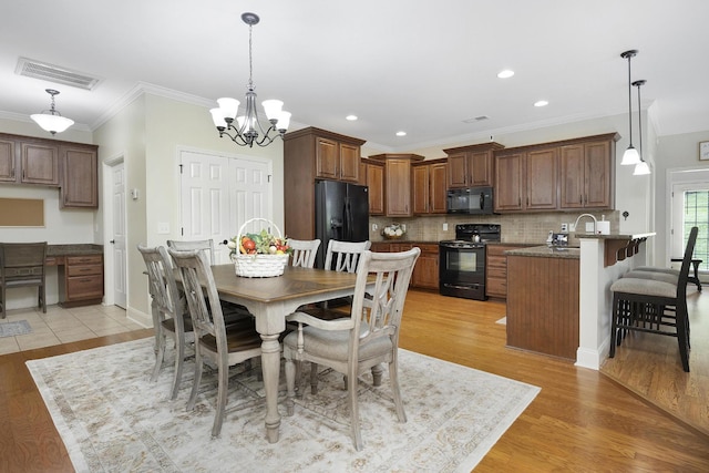 dining room with crown molding, an inviting chandelier, light wood-style floors, recessed lighting, and visible vents