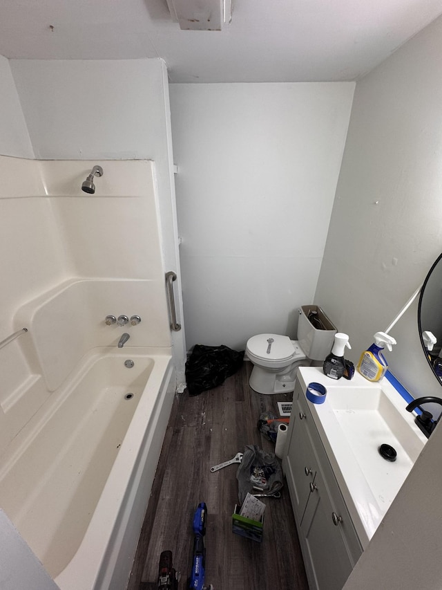bathroom with vanity, washtub / shower combination, toilet, and wood finished floors