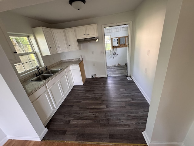 kitchen with a sink, plenty of natural light, white cabinetry, baseboards, and dark wood-type flooring