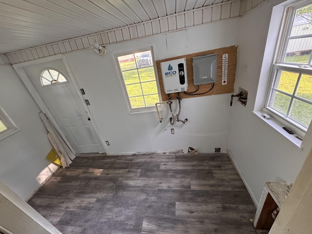 laundry area featuring baseboards, a wealth of natural light, wood finished floors, and water heater