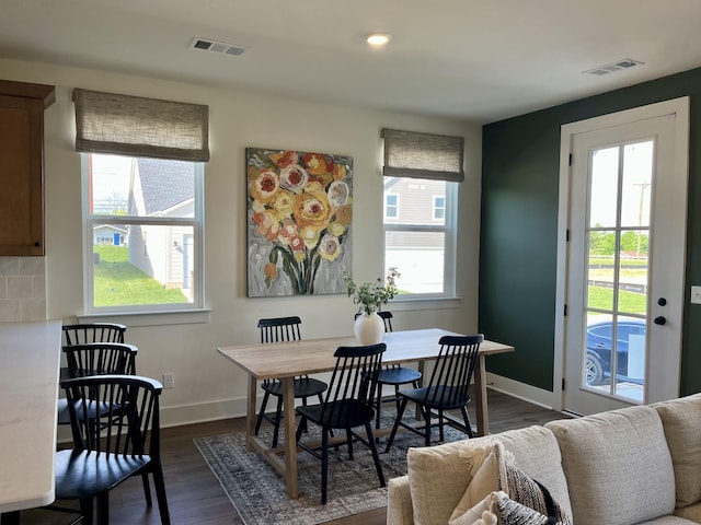 dining area featuring baseboards, dark wood finished floors, and visible vents