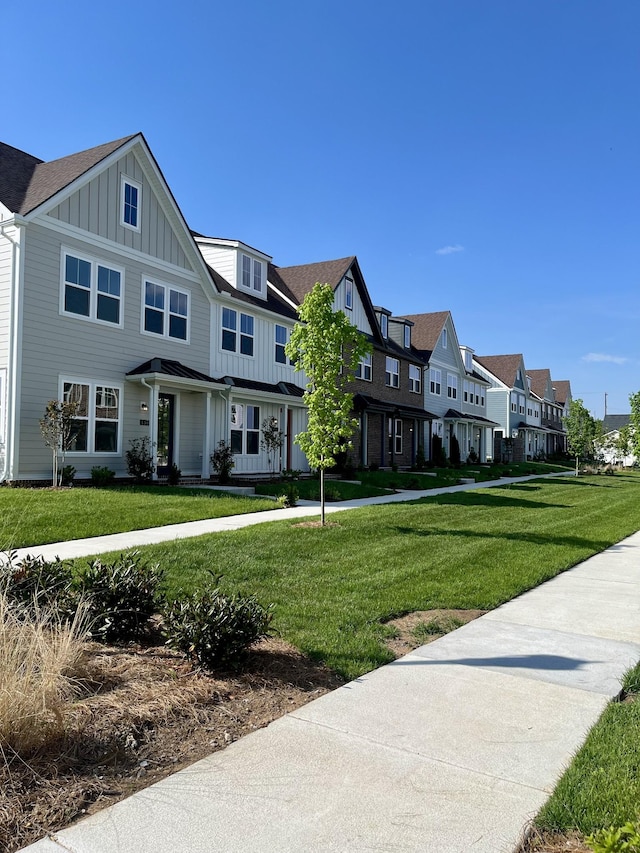 view of home's community featuring a lawn and a residential view
