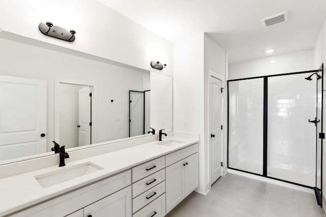 bathroom featuring visible vents, a sink, a stall shower, and double vanity