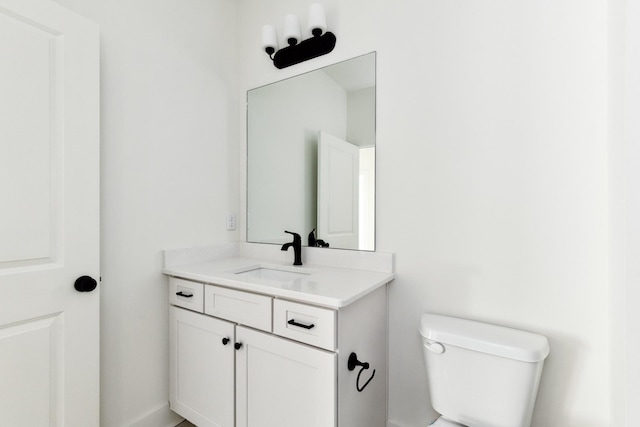 half bath featuring vanity and toilet