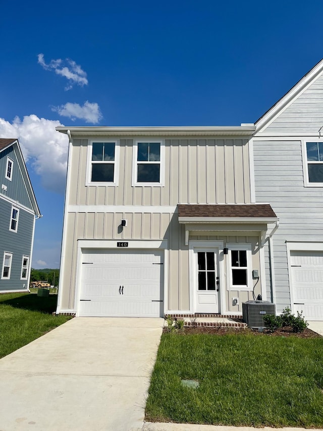 view of front of house with board and batten siding, a front yard, central air condition unit, concrete driveway, and an attached garage
