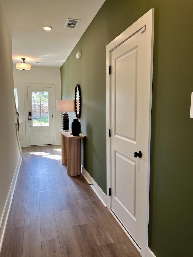 doorway with recessed lighting, baseboards, visible vents, and wood finished floors