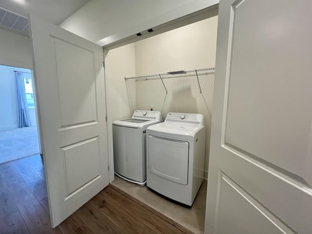 laundry area featuring light wood-style floors, separate washer and dryer, laundry area, and visible vents