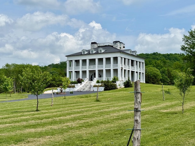 back of property featuring a porch and a yard