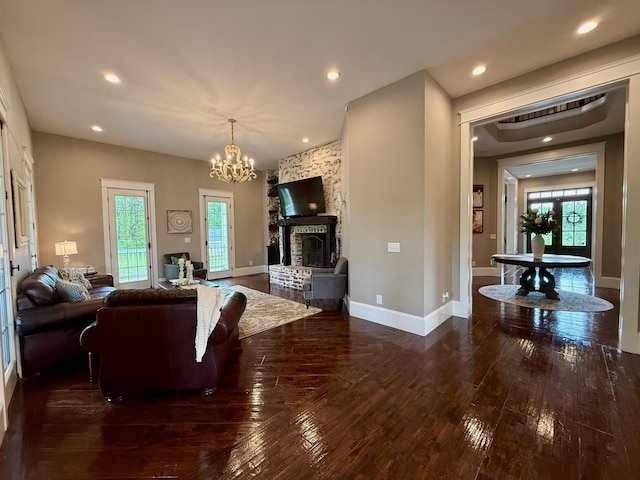 living room featuring wood-type flooring, recessed lighting, baseboards, and a notable chandelier