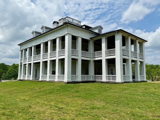 back of property featuring a lawn and a chimney