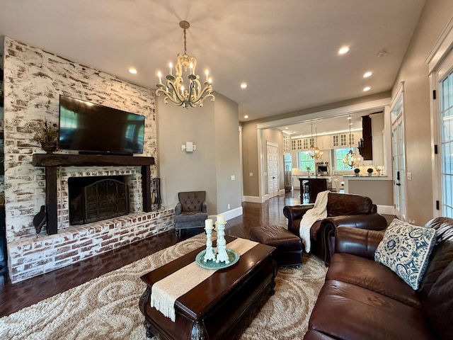 living room featuring baseboards, a notable chandelier, and wood finished floors