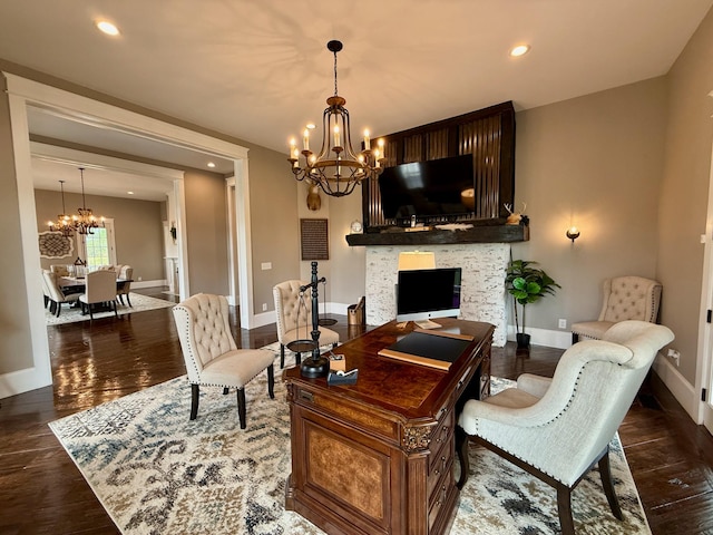 living room featuring an inviting chandelier, baseboards, wood finished floors, and a fireplace