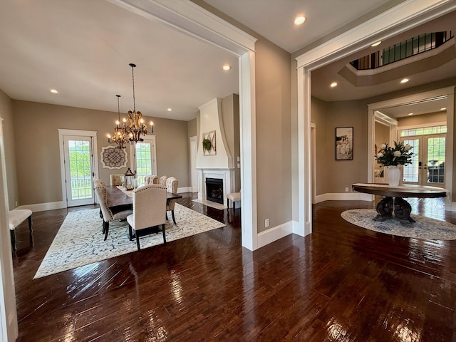 dining space with wood-type flooring, baseboards, a chandelier, and a healthy amount of sunlight