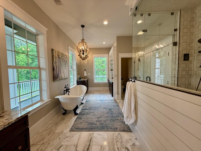 full bath featuring baseboards, a chandelier, a shower stall, and a freestanding tub