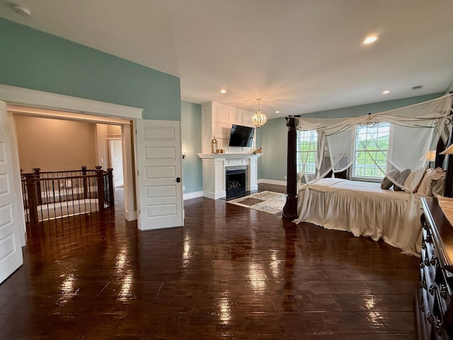 bedroom featuring a high end fireplace, wood-type flooring, and recessed lighting
