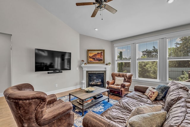 living room featuring baseboards, ceiling fan, vaulted ceiling, and a healthy amount of sunlight