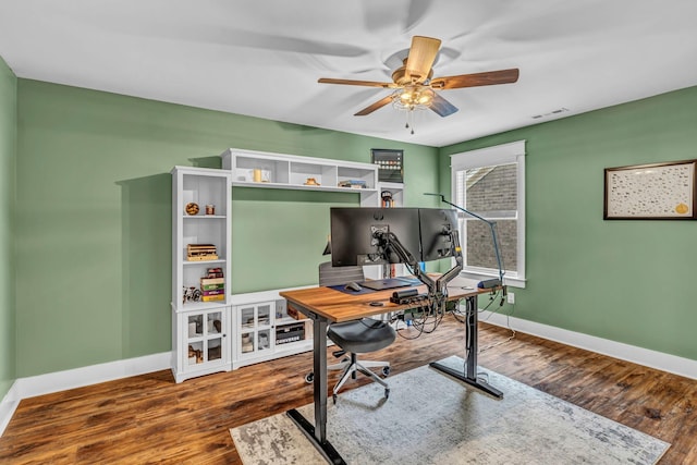 home office featuring baseboards, ceiling fan, wood finished floors, and visible vents