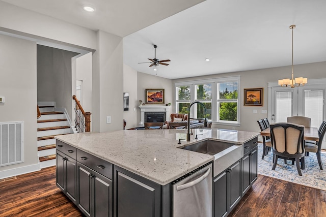 kitchen featuring a sink, stainless steel dishwasher, dark wood-type flooring, and visible vents