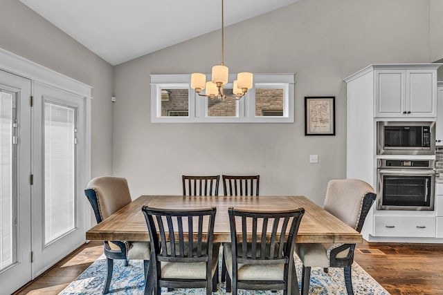 dining area with a notable chandelier, dark wood-style floors, and lofted ceiling