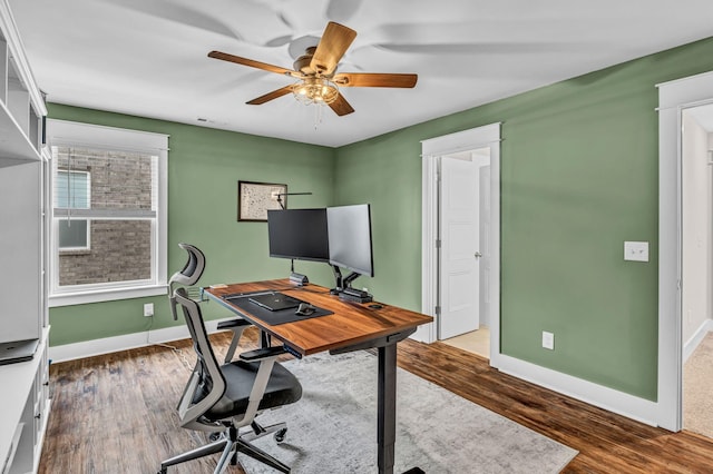 office space with baseboards, ceiling fan, wood finished floors, and visible vents