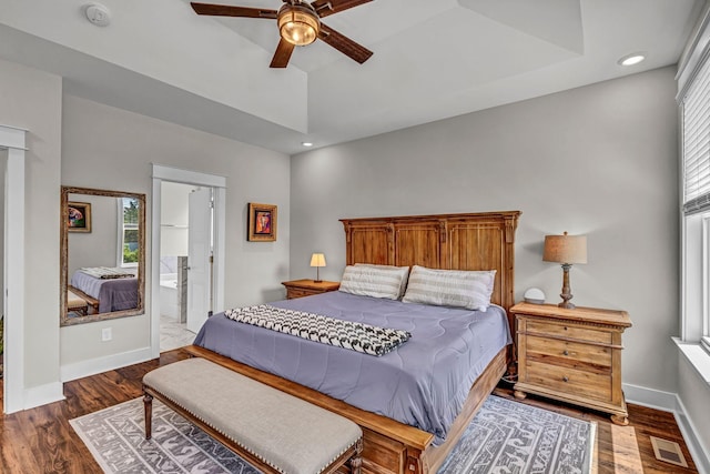 bedroom with baseboards, multiple windows, and wood finished floors