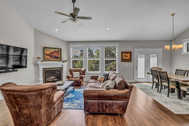 living room with vaulted ceiling, plenty of natural light, and a glass covered fireplace