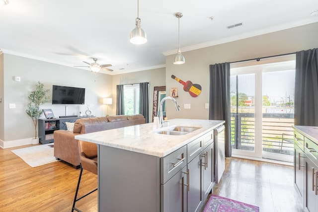 kitchen featuring gray cabinets, a sink, light wood finished floors, and dishwasher