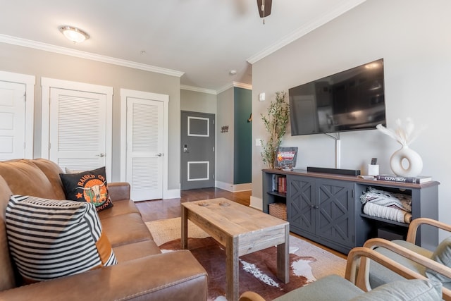living room featuring crown molding, baseboards, and wood finished floors