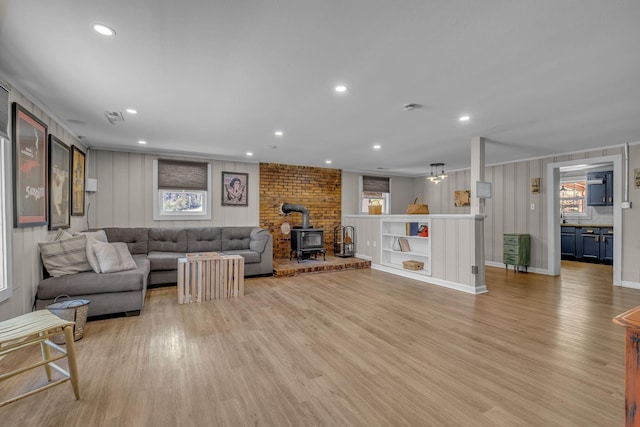 2075 Buttrey Rd, Bon Aqua, TN 37025 - living area featuring light wood-type flooring, a wood stove, baseboards, and recessed lighting