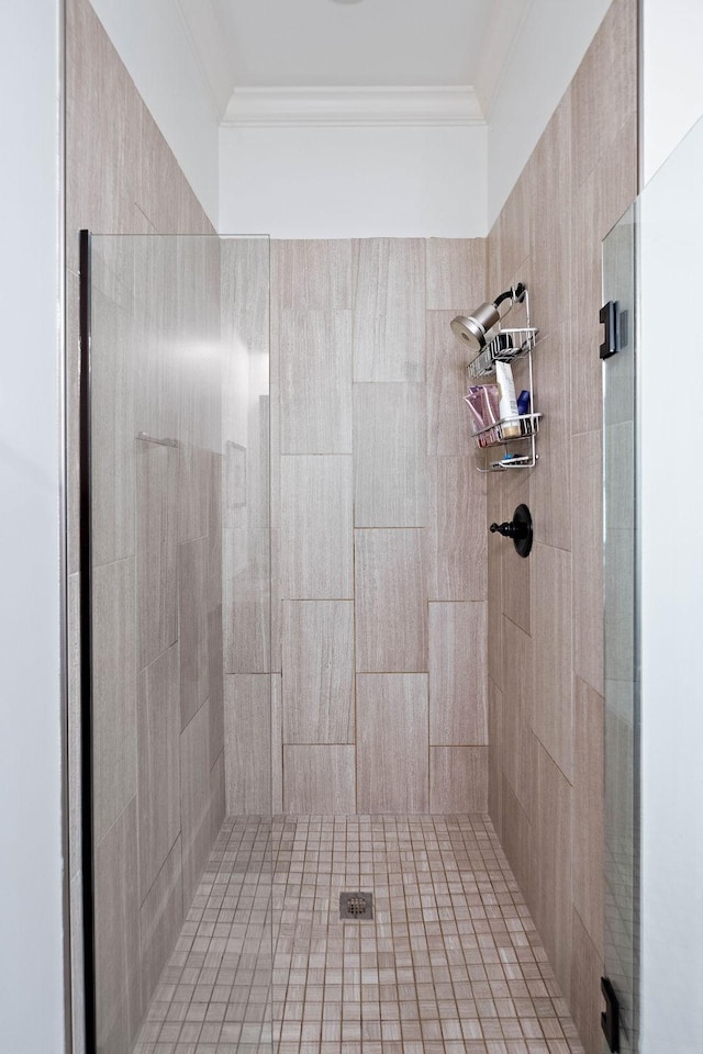 bathroom with ornamental molding and a shower stall