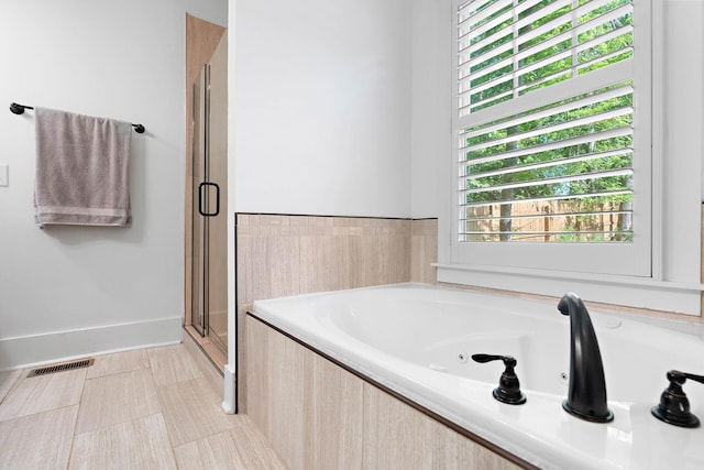 full bathroom with visible vents, a tub with jets, and a stall shower