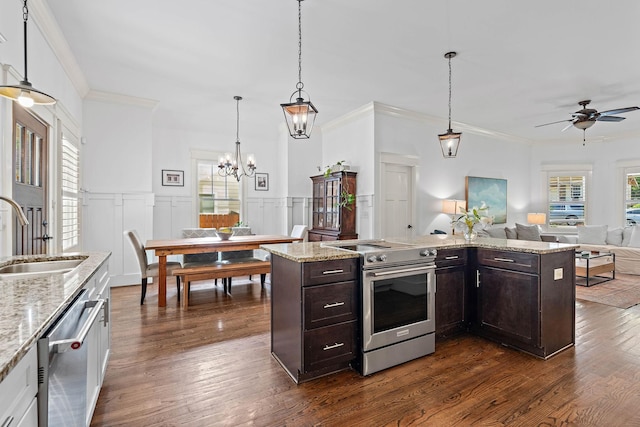 kitchen featuring stainless steel appliances, open floor plan, plenty of natural light, and a sink
