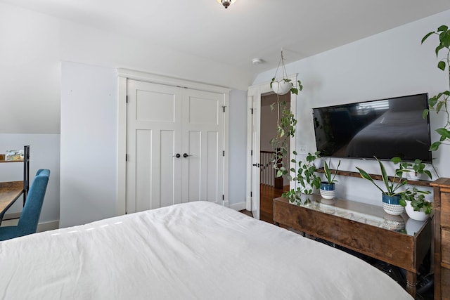 bedroom featuring baseboards, a closet, and wood finished floors
