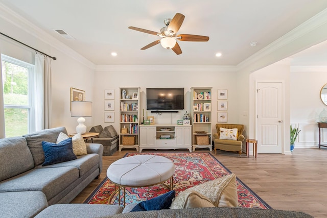living room featuring a ceiling fan, ornamental molding, and wood finished floors
