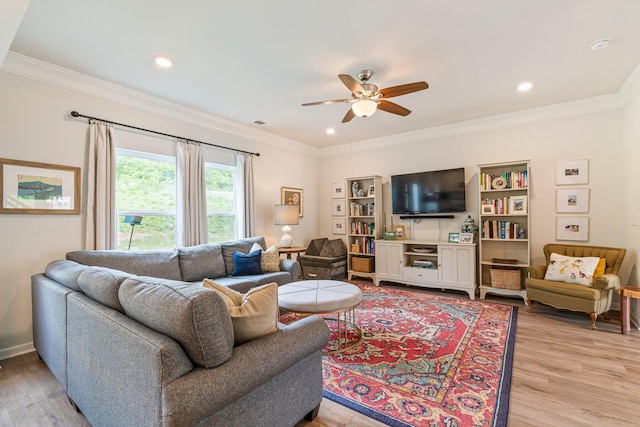 living room featuring ornamental molding, a ceiling fan, and light wood-type flooring