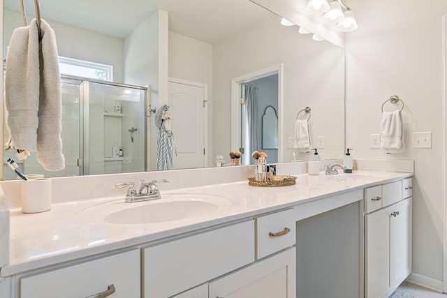 bathroom featuring double vanity, a sink, and a stall shower