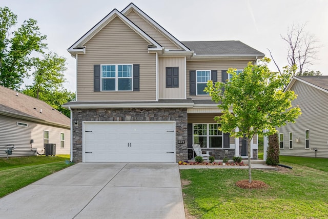 craftsman inspired home with concrete driveway, central AC unit, stone siding, and a front lawn