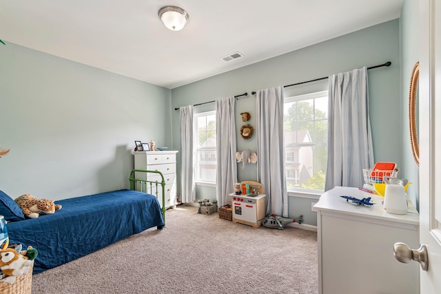 bedroom featuring visible vents and light carpet