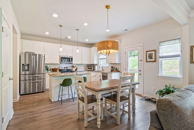 dining area featuring visible vents, a toaster, baseboards, light wood-style floors, and recessed lighting
