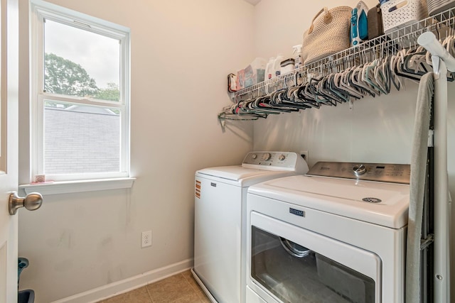 laundry room with light tile patterned floors, baseboards, laundry area, and washer and dryer