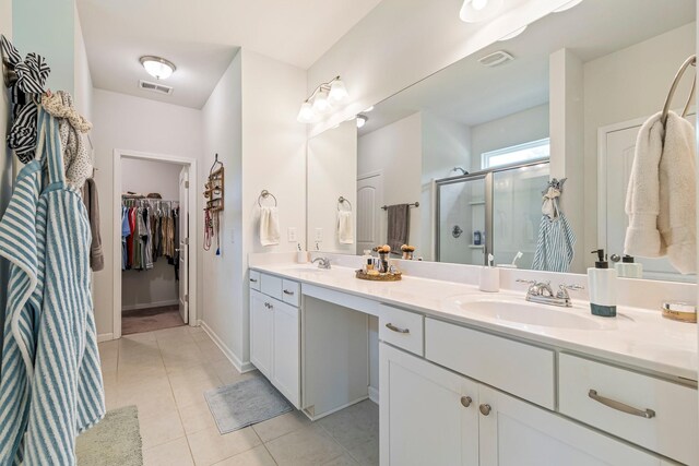 full bath with visible vents, a sink, tile patterned flooring, and a stall shower