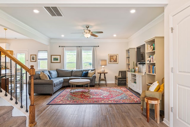 living area with visible vents, stairs, ceiling fan, and wood finished floors