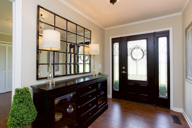 foyer entrance featuring crown molding, baseboards, dark wood-style flooring, and visible vents