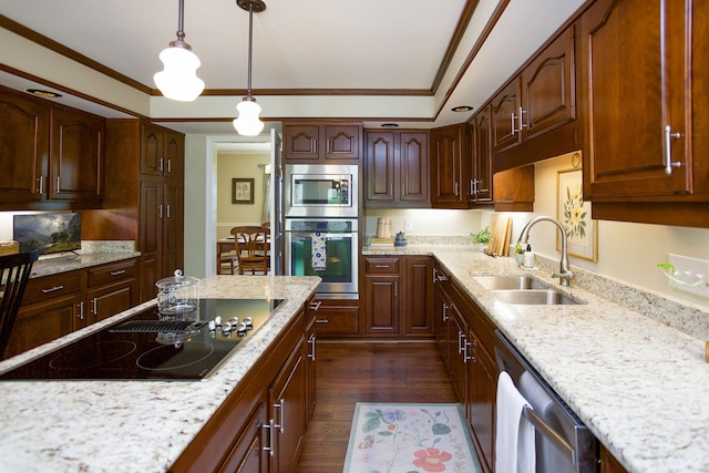 kitchen featuring dark wood-style flooring, hanging light fixtures, appliances with stainless steel finishes, a sink, and light stone counters