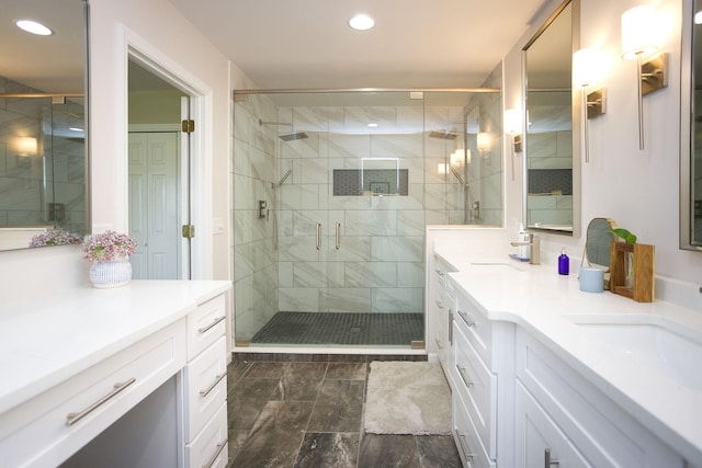 bathroom with double vanity, a stall shower, recessed lighting, and a sink