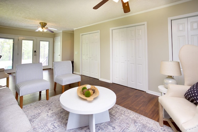 living area with french doors, a textured ceiling, a ceiling fan, and wood finished floors