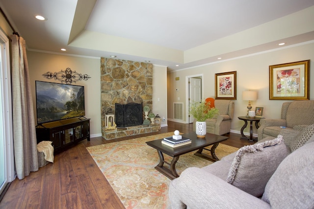 living area with visible vents, ornamental molding, and a tray ceiling