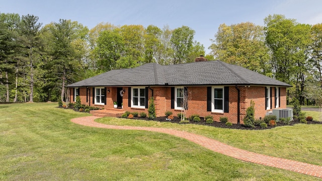 ranch-style home with a chimney, a front yard, central air condition unit, brick siding, and a shingled roof
