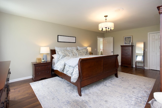 bedroom featuring baseboards, wood finished floors, and a chandelier